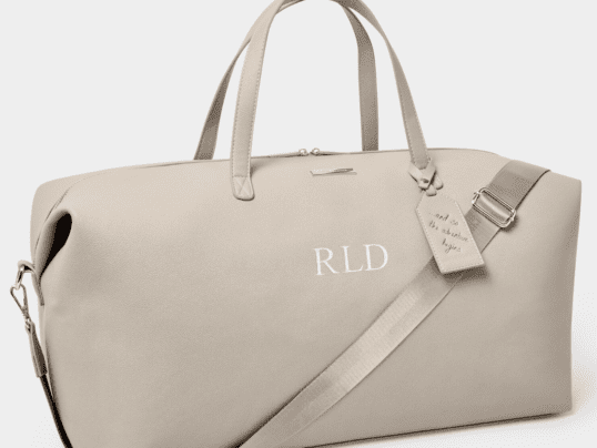 A Beige Color Handbag With a Inprinted Tag Image